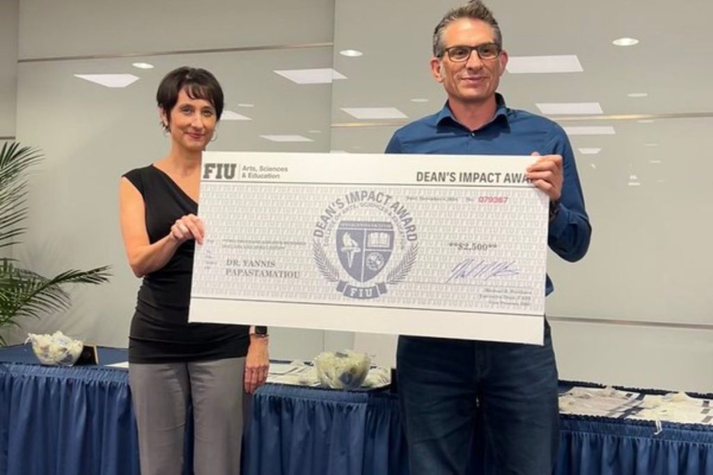 Dr. Yannis Papastamatiou receives check for Dean's Impact Award.